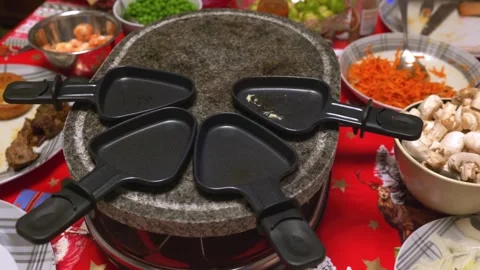 Tabletop grill with grilling plates filled with food being cooked and shared Stock Footage 323227023