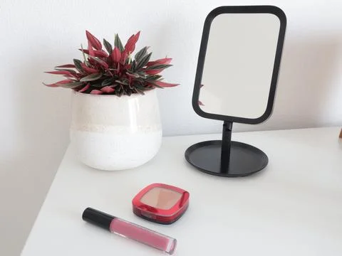 Tabletop mirror and cosmetics on dressing table. Perfumes and beauty products Stock Photos