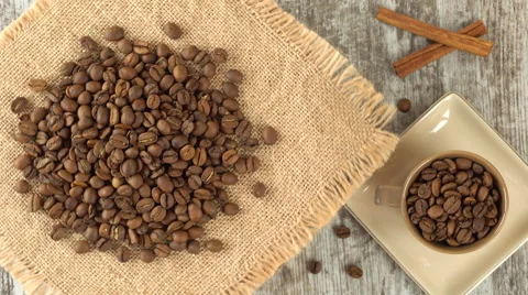 Tabletop of roasted coffee beans rotating on burlap. Rustic wooden background Video stock 67581306