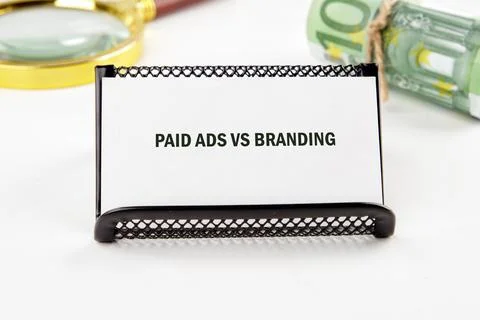 A tabletop scene highlights a card reading paid ads vs branding, framed by a  Stock Photos