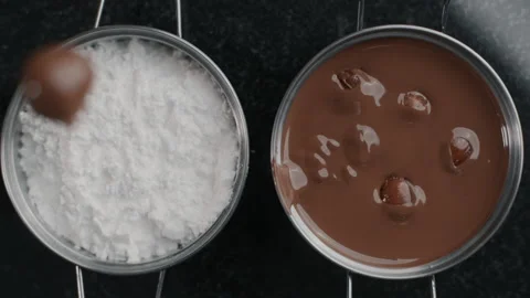 Tabletop shot: chef chocolatier drops truffles to the sugar powder in slow Stock Footage 133569761