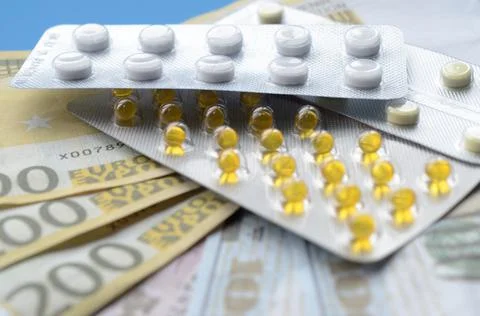 Tablets and banknotes. The concept of imposing medical drugs. Stock Photos