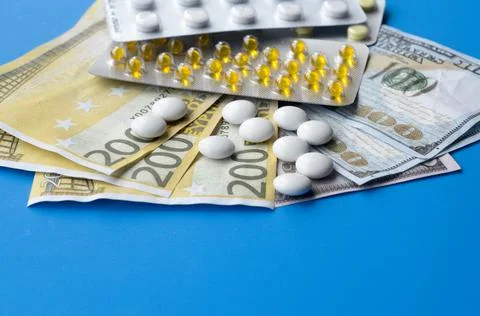 Tablets and banknotes. The concept of imposing medical drugs. Stock Photos
