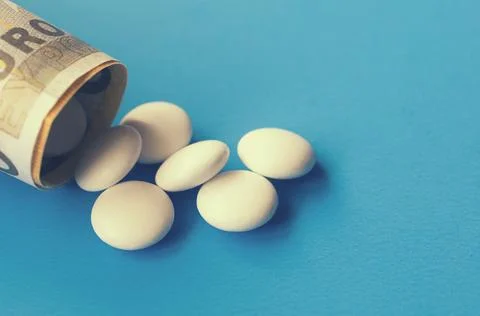 Tablets and banknotes. The concept of imposing medical drugs. Stock Photos