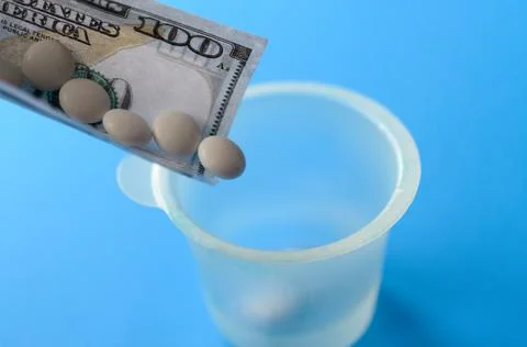 Tablets and banknotes. The concept of imposing medical drugs. Stock Photos