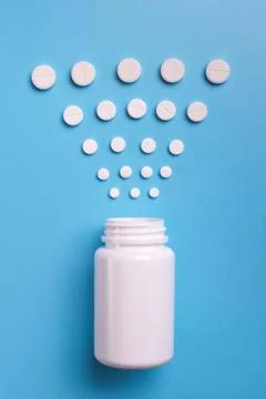 Tablets and bottle on blue background Stock Photos