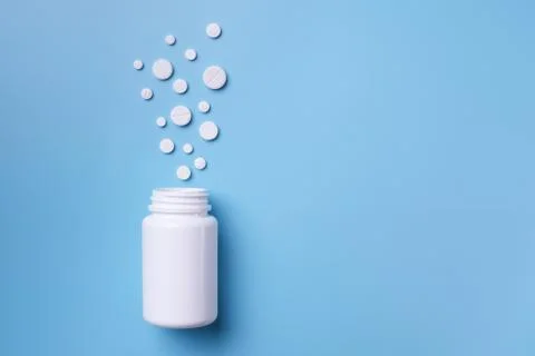 Tablets and bottle on blue background Stock Photos