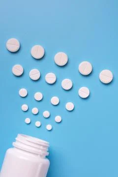 Tablets and bottle on blue background Stock Photos