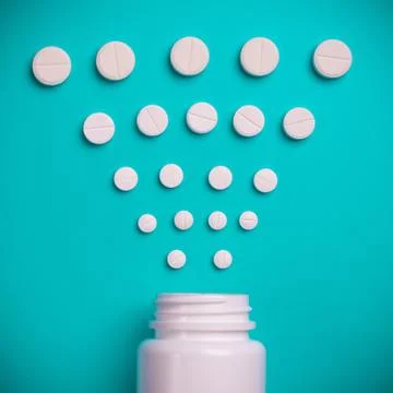 Tablets and bottle on blue background Stock Photos