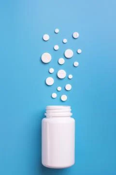 Tablets and bottle on blue background Stock Photos
