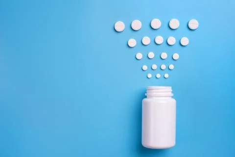 Tablets and bottle on blue background Stock Photos