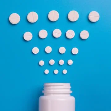 Tablets and bottle on blue background Stock Photos