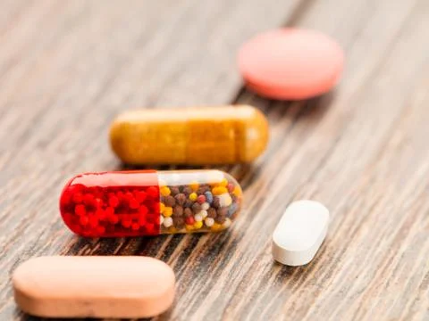 Tablets and capsules in the lid Stock Photos