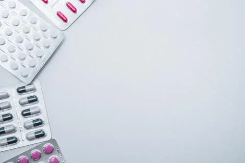 Tablets and capsules in the package lie on the side on a white background with a Stock Photos