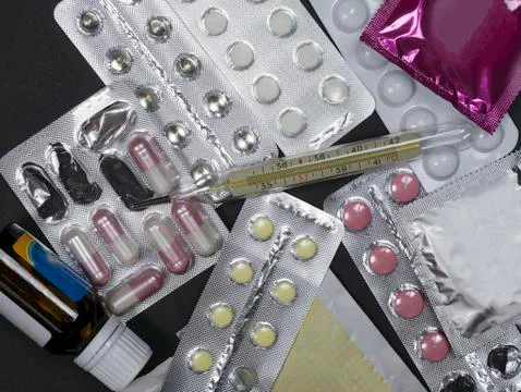 Tablets and thermometer on black background Stock Photos