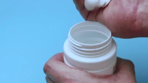 Tablets are thrown into a jar on a blue background. Stock Footage 140968897