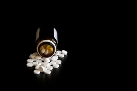 Tablets on a black background from a jar. jar with pills on a black background Stock Photos