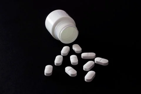 Tablets on a black background from a jar Foto stock