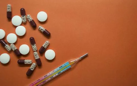 Tablets, capsules and thermometer Stock Photos