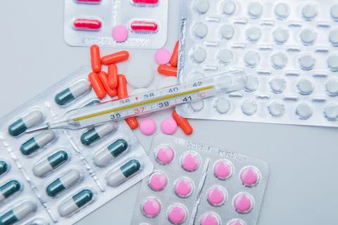 Tablets in capsules in packages and without lie on the entire surface of the Stock Photos