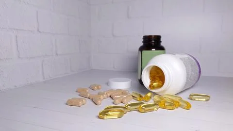 Tablets in capsules scattered on a light background Stock Photos