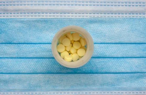 Tablets in container on blue mask background Stock Photos