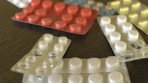 Tablets fall on the table. Antibiotics for flu. HD Vídeo Stock 98400422