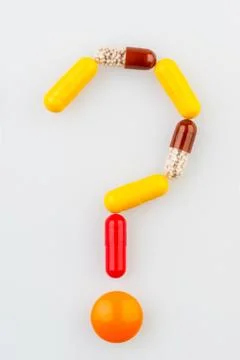 Tablets in the form of a question mark on the medical table Foto stock