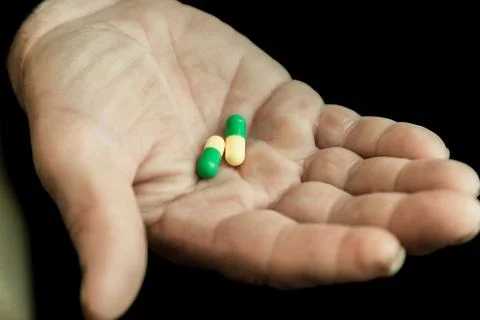 Tablets in the hand of an elderly man Stock Photos