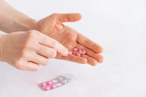 Tablets in hand on a white background close-up. Stock Photos