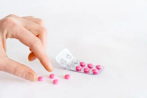 Tablets in hand on a white background close-up. Stock Photos
