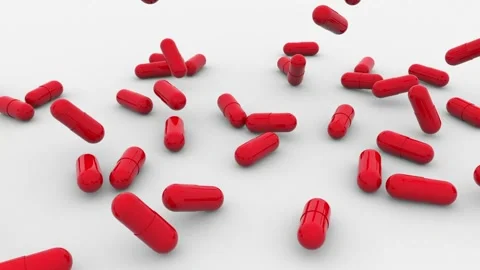 The tablets in hard, shiny red gelatin capsules fall onto a white surface Stock Footage 164614724