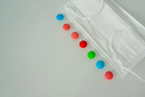 Tablets or sweets, white and colored on a white glass table Foto stock