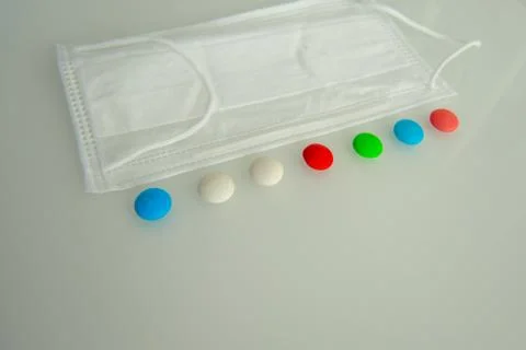 Tablets or sweets, white and colored on a white glass table Stock Photos