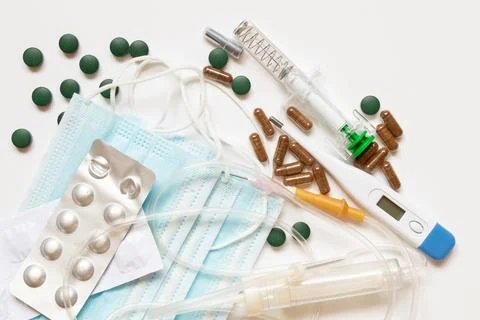 Tablets in a package, a dropper and a syringe with a thermometer are lying .. Stock Photos