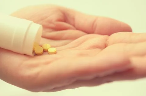 Tablets with a package in the palm of a close-up. Stock Photos