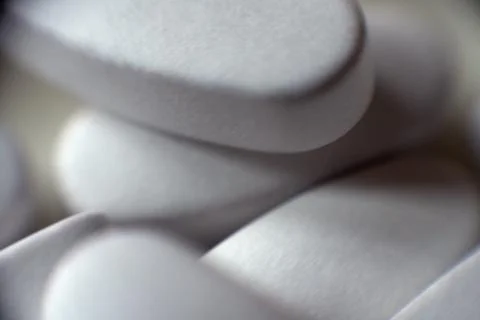 Tablets piled closely together. White pills close up. Foto stock