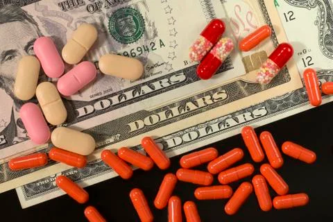 Tablets, pills, capsules on dollars background Stock Photos