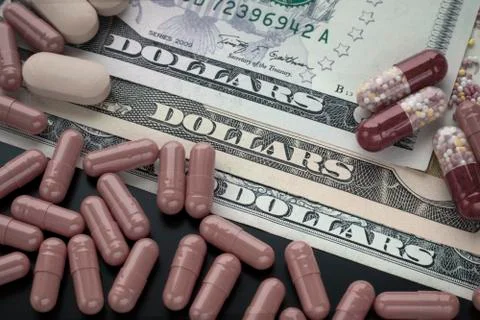 Tablets, pills, capsules on dollars background in repulsive colors Stock Photos