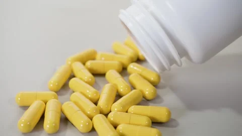 Tablets pills spilling from plastic pill bottle on natural background Video stock 266648746