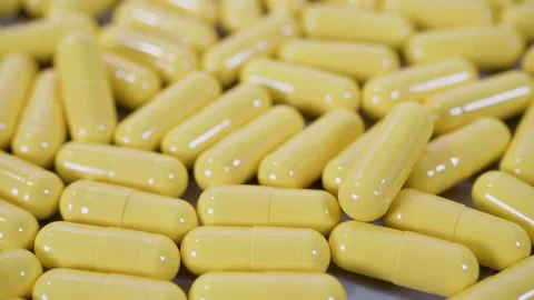 Tablets pills spilling from plastic pill bottle on natural background Video stock 266648956