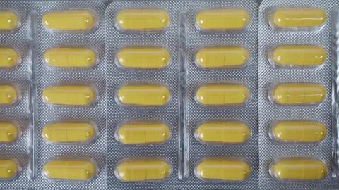 Tablets pills spilling from plastic pill bottle on natural background Video stock 266649043