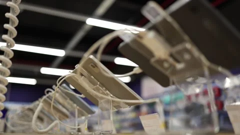 Tablets on security stands displayed for comparison in electronics store Stock Footage 345359423