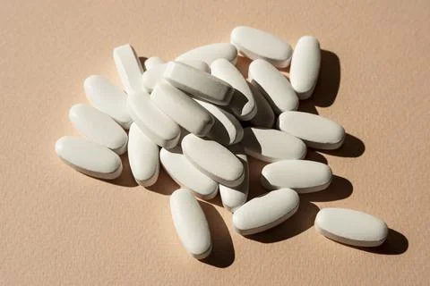 Tablets, vitamins on a light pink background, a minimalist concept Foto stock