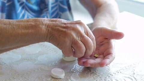 Tablets in wrinkled hands of the old lady Stock Footage 77214484