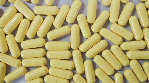 Tablets, yellow capsules on natural background. Pills for heart and vascular Video stock 266648925