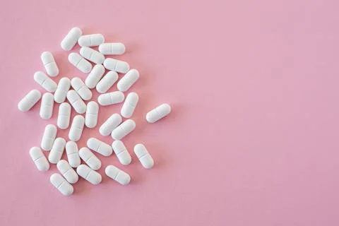 Tabletten or pillen in white package on the pink background with place for .. Stock Photos
