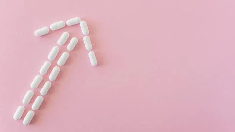 Tabletten or pillen in white package on the pink background with place for .. Stock Photos