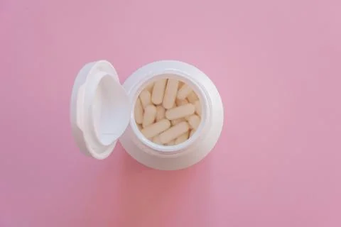 Tabletten or pillen in white package on the pink background with place for .. Stock Photos