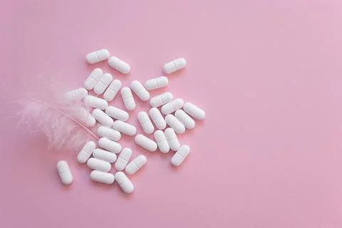 Tabletten or pillen in white package on the pink background with place for .. Stock Photos